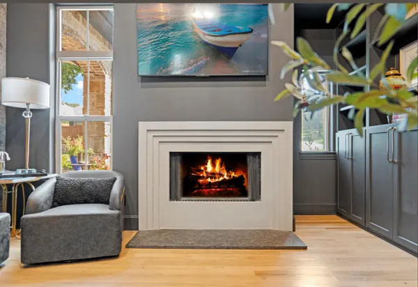 Study with a fireplace in a stepped surround and charcoal cabinets