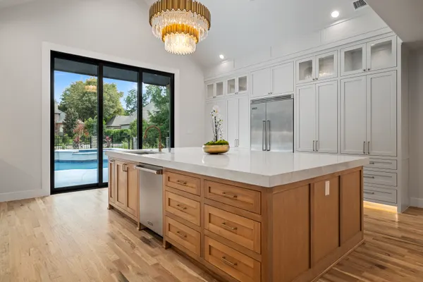 Wood island and white cabinetry, with sliding doors out to the pool