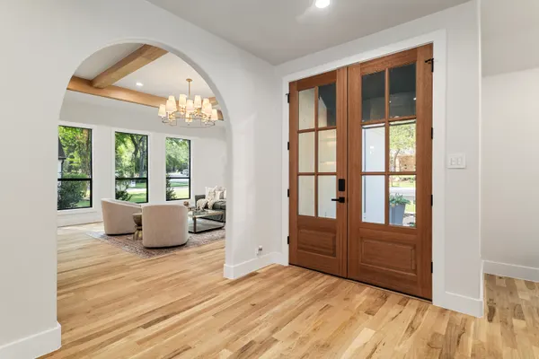 Arched opening into the living room, beside wood and glass double doors