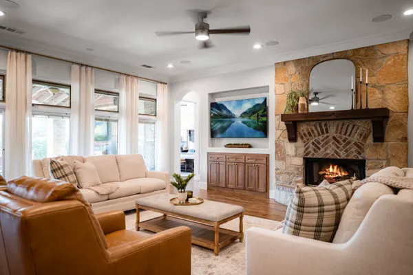 Family room with a stone fireplace and a wall of windows