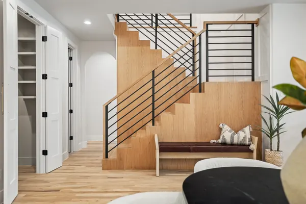 Wood-clad stair with a black railing and a built-in bench