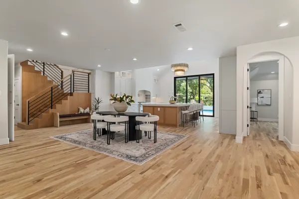 Dining area with a round table beside the wood-clad stair