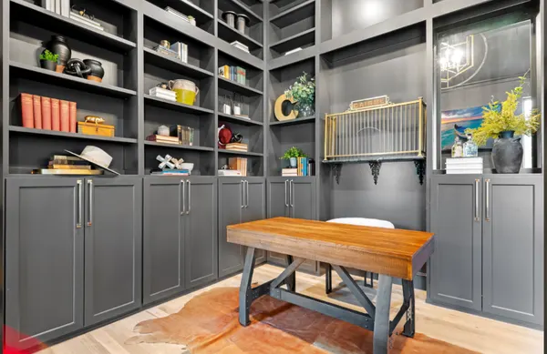 Charcoal built-in shelves and cabinets around a wood desk