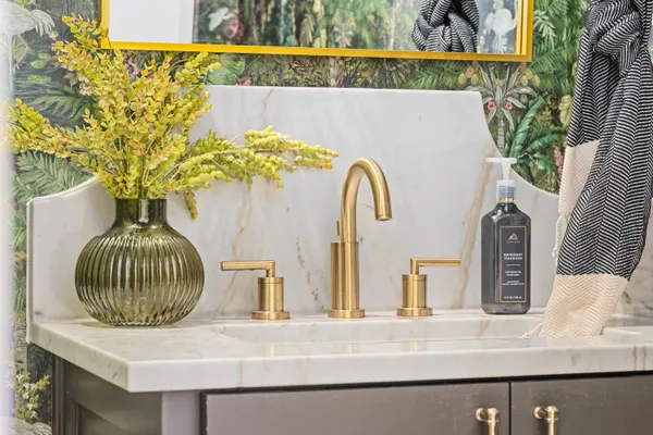 Brass faucet and stone backsplash in the powder room