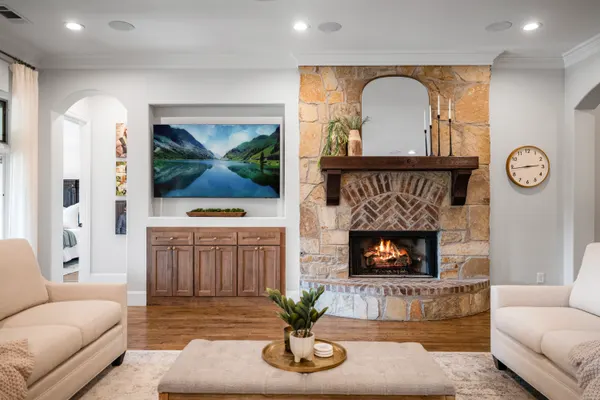 Stone fireplace with a wood mantel and an arched mirror