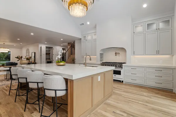 Kitchen open to the dining area, with a long island and white stools