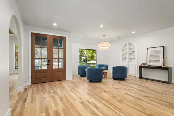 Front room with wood and glass double doors and an arched niche