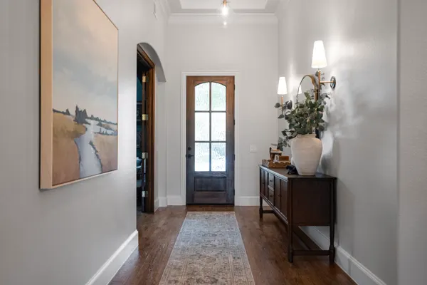 Entry hall leading to an arched wood front door