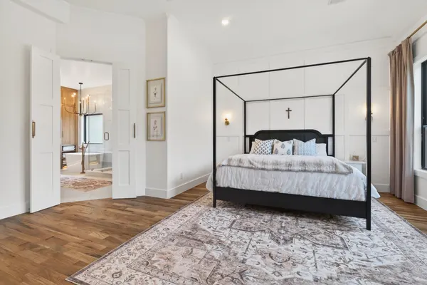 Primary bedroom with double doors open to the primary bath