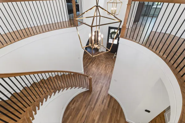 The curved stair from the landing, looking down to the entry