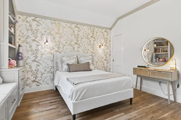 Bedroom with gold botanical wallpaper and built-in drawers