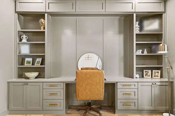 Built-in desk with shelves and cabinets on each side, and brass pulls