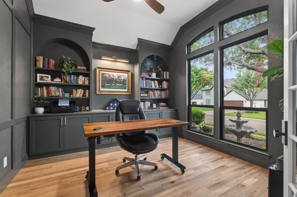 Study with charcoal built-in shelves in arched niches and tall black-framed windows