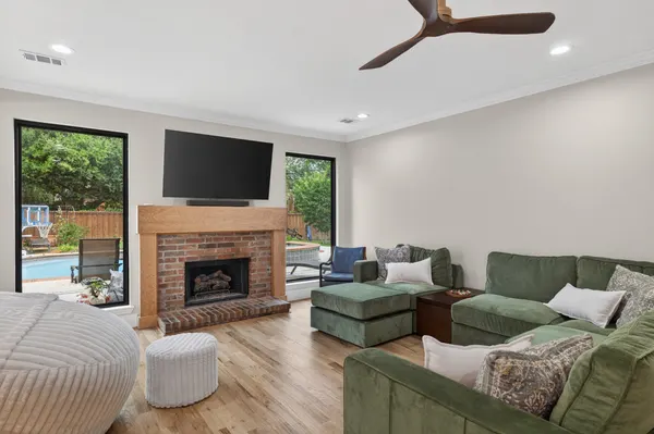 Brick fireplace with a wood mantel between black-framed windows