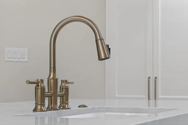 Brass bridge faucet at the island sink