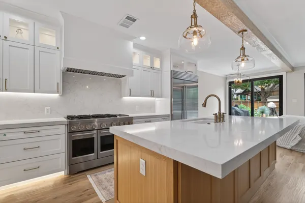 Kitchen island and range, with black-framed sliding doors to the backyard beyond