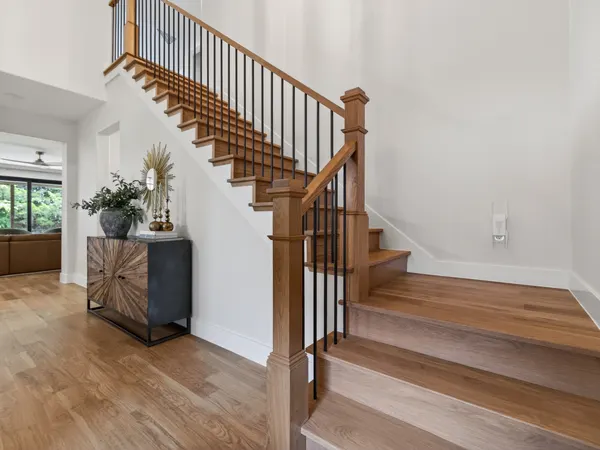 Stair with wood treads, a wood handrail and black metal balusters