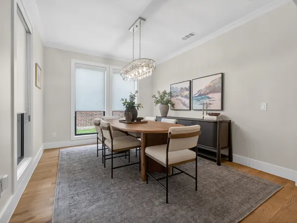 Dining room with a chandelier over the table and tall windows