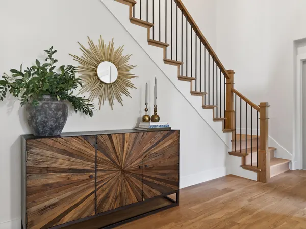 The stair from the hall, with wood treads and black metal balusters