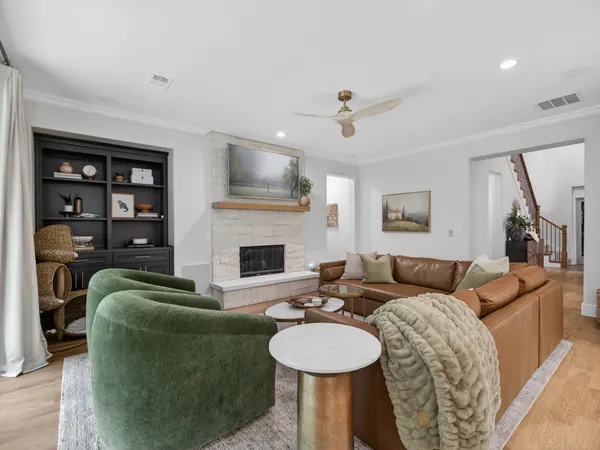 Stone fireplace with a wood mantel beside charcoal built-in shelves