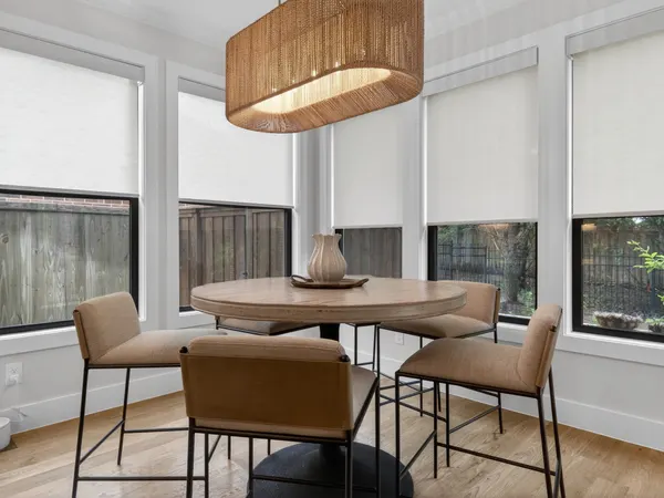 Breakfast nook under a woven pendant, with black-framed windows