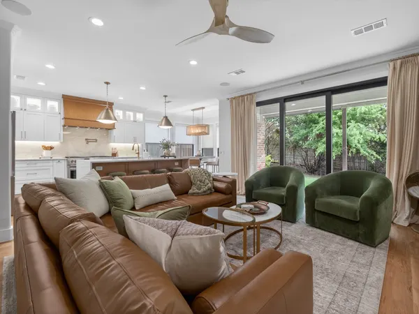 Living room open to the kitchen, with black-framed sliding doors to the backyard