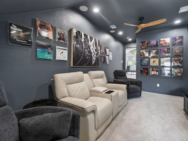 Media room with theater recliners and framed posters on charcoal walls